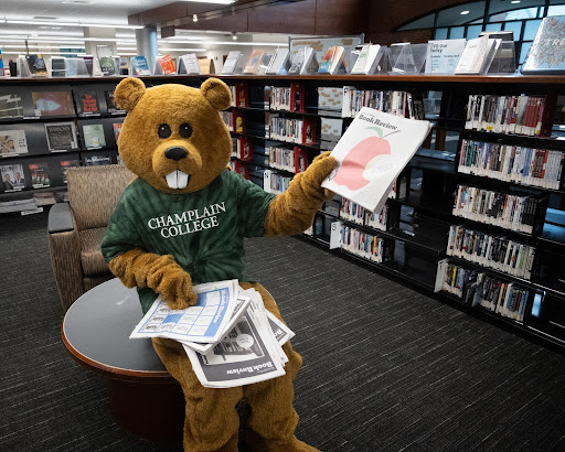 Mascot Chauncey the Beaver going through a stack of the New York Times Book Review publication